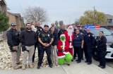 Local police officials and other join Santa and The Grinch for the POlice department's annual Presents on Patrol event.